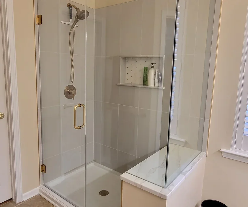 Ceramic shower tile and custom glass enclosure detail from a bathroom renovation