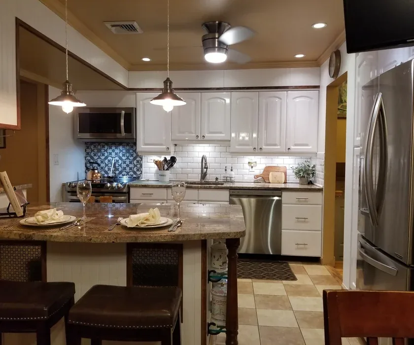 Stone countertop edge and tile backsplash detail in a remodeled kitchen