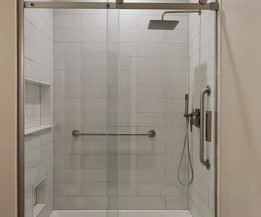 Ceramic shower tile and custom glass enclosure detail from a bathroom renovation