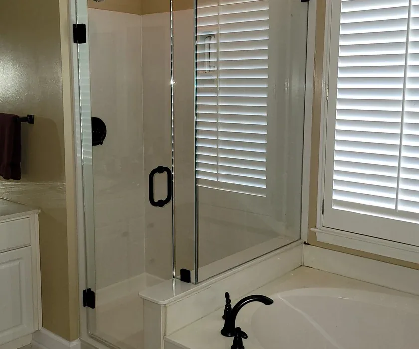 Ceramic shower tile and custom glass enclosure detail from a bathroom renovation